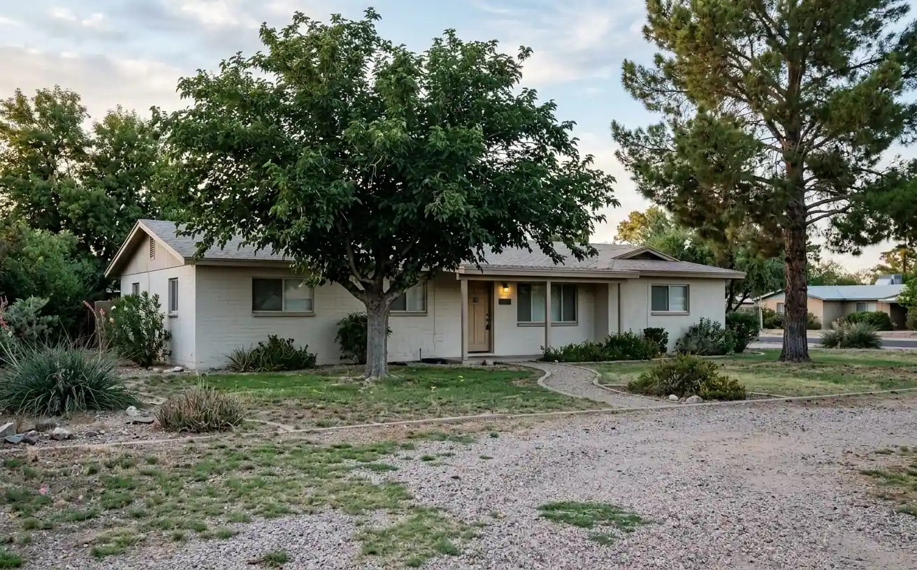 Older single story ranch home with mature trees, typical of central Las Vegas neighborhoods built before 1980